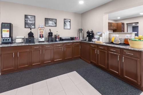 a large kitchen with wooden cabinets and a counter top at Super 8 by Wyndham Bridgeport/Clarksburg Area in Bridgeport