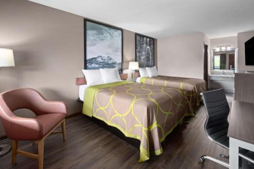 a hotel room with a bed and a chair at Super 8 by Wyndham Bridgeport/Clarksburg Area in Bridgeport