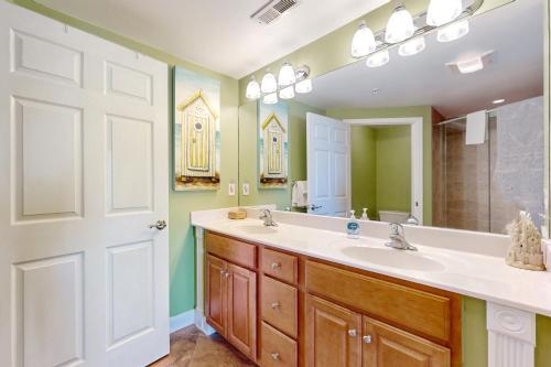 une salle de bain avec un lavabo et un grand miroir dans l'établissement Oceans Mist 403, à Ocean City