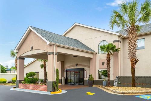 a building with palm trees in front of it at Ramada by Wyndham Locust Grove in Locust Grove