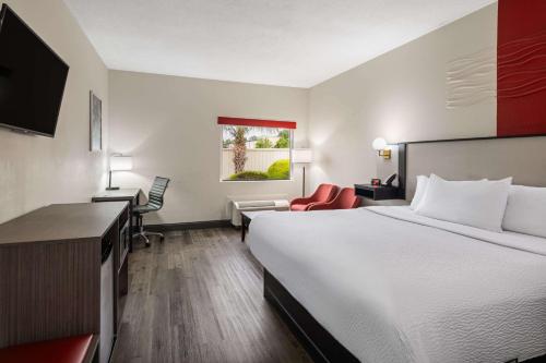 a hotel room with a large bed and a desk at Ramada by Wyndham Locust Grove in Locust Grove