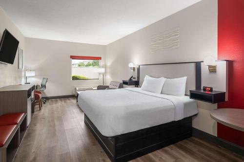 a hotel room with a large bed and a desk at Ramada by Wyndham Locust Grove in Locust Grove