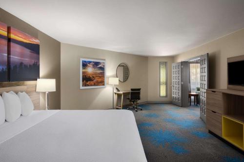 a hotel room with a bed and a flat screen tv at Days Inn by Wyndham Klamath Falls in Klamath Falls