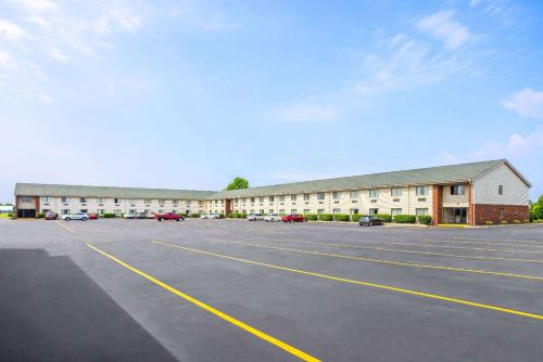 an empty parking lot in front of a large building at Super 8 by Wyndham Henrietta/Rochester Area in Henrietta