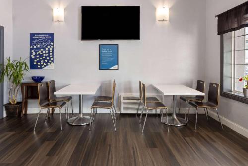 a dining room with tables and chairs and a flat screen tv at Days Inn by Wyndham Aberdeen in Aberdeen
