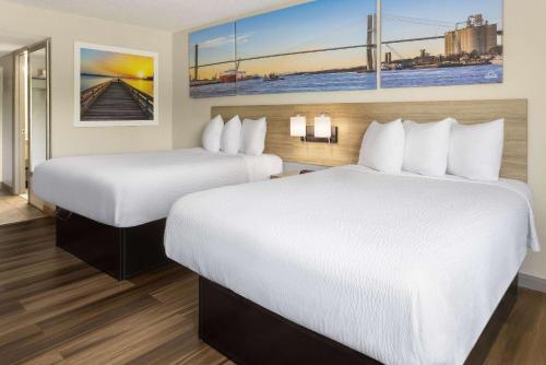a hotel room with two beds and a painting on the wall at Days Inn by Wyndham Aberdeen in Aberdeen