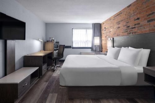 a hotel room with a large bed and a desk at Travelodge by Wyndham Barrie in Barrie