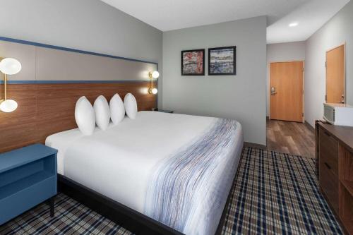 a hotel room with a large bed and a television at AmericInn by Wyndham Eagle River Downtown in Eagle River