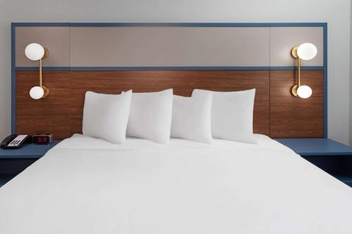 a large white bed with white pillows in a hotel room at AmericInn by Wyndham Eagle River Downtown in Eagle River