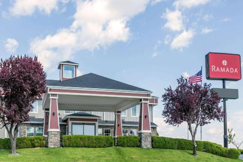 a hotel with a sign in front of a building at Ramada by Wyndham Moses Lake in Moses Lake