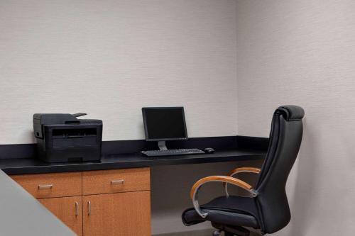 an office with a desk with a computer and a chair at Wingate by Wyndham Louisville East in Louisville
