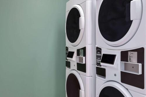 two washing machines are stacked against a wall at Wingate by Wyndham Louisville East in Louisville