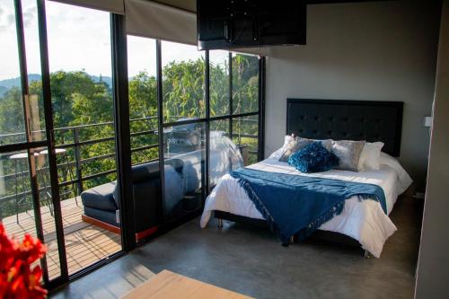 a bedroom with a bed and a balcony with windows at Eco Lodge Glamping in Guatapé