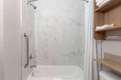 a bathroom with a white tub and a shower at Microtel Inn & Suites by Wyndham Panama City in Panama City