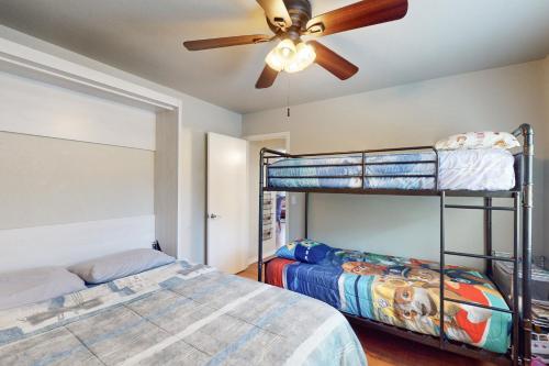 a bedroom with two bunk beds and a ceiling fan at The Forest Cottage in Payson