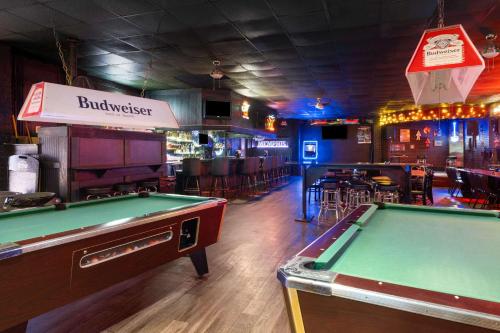 a bar with a pool table and a bar with chairs at Super 8 by Wyndham Longview/North in Longview
