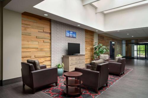 a lobby with a waiting room with chairs and a tv at Wyndham Garden Inn Pittsburgh Airport in Robinson Township