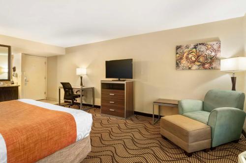 a hotel room with a bed and a flat screen tv at Best Western Heritage Inn Chico in Chico