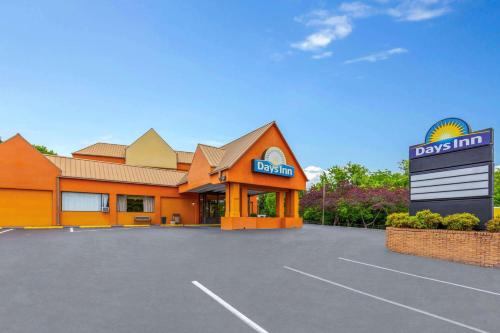 a front view of a day inn with a parking lot at Days Inn by Wyndham Knoxville East in Knoxville