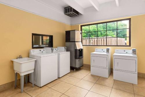 a laundry room with four washes and a window at Days Inn by Wyndham Knoxville East in Knoxville