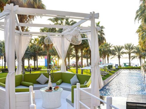 a pergola over a pool at a resort at Rixos The Palm Hotel & Suites - Ultra All Inclusive in Dubai