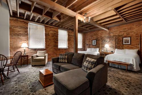 a living room with a bed and a couch and a bedroom at The Historic Brookstown Inn, Trademark Collection by Wyndham in Winston-Salem