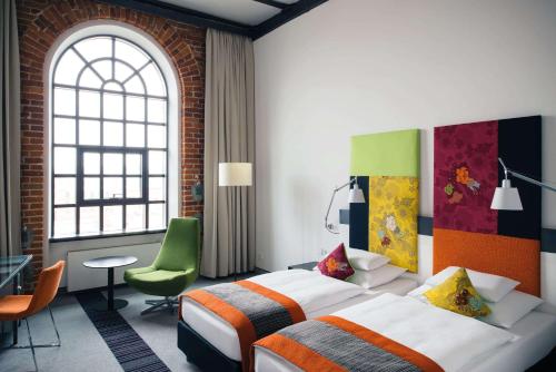 a hotel room with two beds and a window at Vienna House by Wyndham Andel's Lodz in Łódź