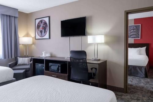 a hotel room with a bed and a desk with a computer at Ramada by Wyndham Thunder Bay Airlane Hotel in Thunder Bay