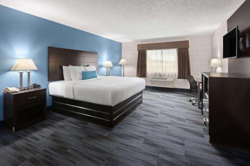a hotel room with a large bed and a window at Baymont Inn and Suites by Wyndham Farmington, MO in Farmington