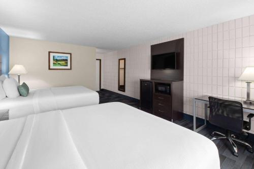 a hotel room with two beds and a flat screen tv at Baymont Inn and Suites by Wyndham Farmington, MO in Farmington