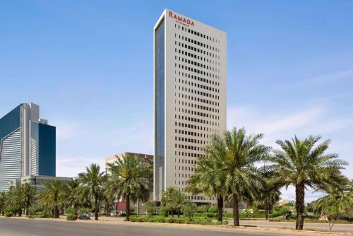 فندق رمادا باي ويندهام الرياض طريق الملك فهد في الرياض: مبنى أبيض طويل عليه علامة