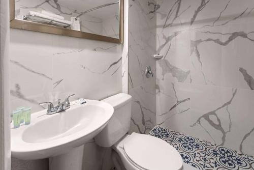 a bathroom with a toilet and a sink at Wildwood Inn Hotel Travelodge Beach & Boardwalk in Wildwood