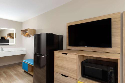 a kitchen with a black refrigerator and a flat screen tv at Days Inn by Wyndham Helen in Helen