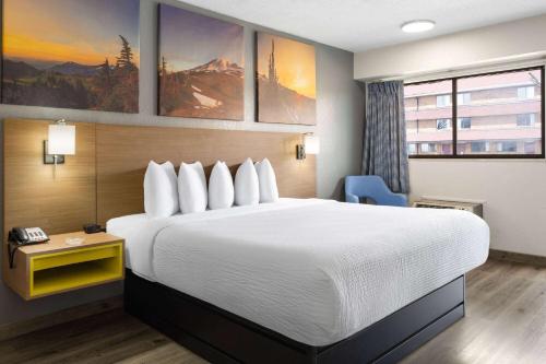a hotel room with a large bed and a telephone at Days Inn by Wyndham Columbus Worthington in Columbus