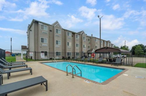 a building with a swimming pool in front of a building at Studio 6 Suites Breaux Bridge, LA in Breaux Bridge