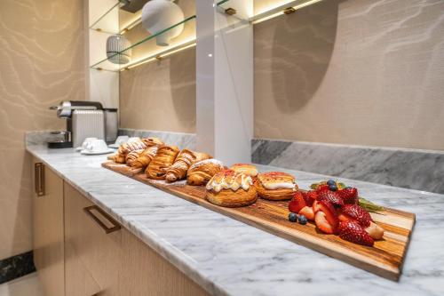a counter with a bunch of pastries and strawberries at AZUR Legacy Collection Hotel in Vancouver