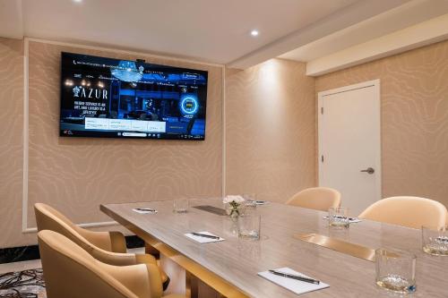 a conference room with a table and a tv on the wall at AZUR Legacy Collection Hotel in Vancouver