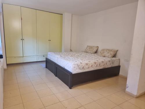 a bedroom with a bed in a room with cabinets at בית פרטי לחופש משפחתי in Bayit Wegan