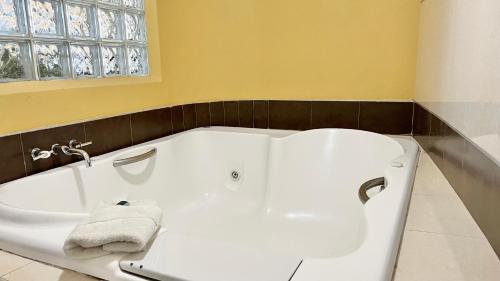 a white bath tub in a bathroom with a window at Hotel Renzzo in Río Verde