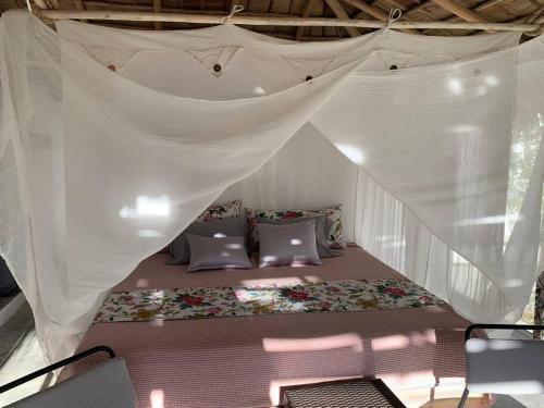 Una cama en una tienda de campaña blanca con mosquitero. en Cocon caraïbéen proche de la plage, en Las Terrenas