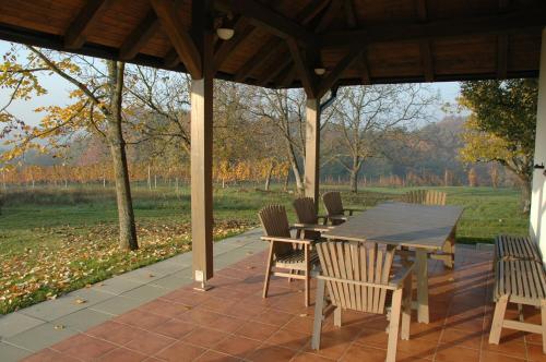 einen Holztisch und Stühle auf einer Terrasse in der Unterkunft Country house Martinova Klet in Prosenjakovci