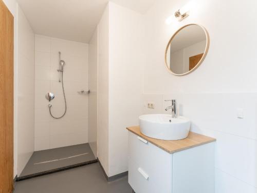 a white bathroom with a sink and a shower at Heimelig L in Saalbach-Hinterglemm