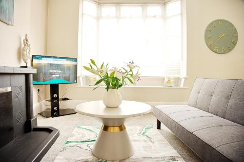een woonkamer met een vaas met bloemen op een tafel bij Parkgate Central, Station & Town in Darlington