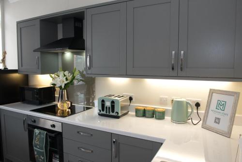 een keuken met witte kasten en een broodrooster op een aanrecht bij Parkgate Central, Station & Town in Darlington