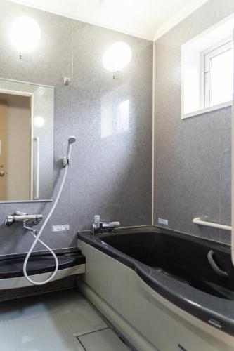 a bathroom with a large mirror and a bath tub at ANSHINDO in Kamikawa