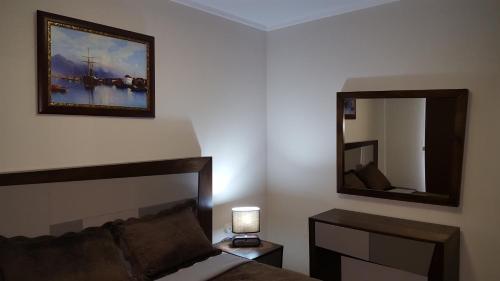 um quarto com uma cama e um espelho na parede em Mimino Apartment Deluxe First Line (K III) em Batumi