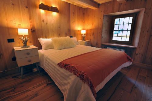 a bedroom with a bed with two night stands and a window at Historic Residenze Loo Bach in Gressoney-Saint-Jean