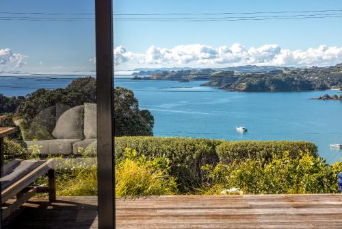 a view of a lake from a porch at Double Bay Views, Oneroa - Be My Guest in Blackpool