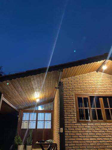 a house with a blue ceiling and a table at Pousada Chales Joao de Barro in Visconde De Maua