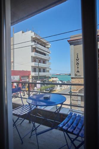 a table and chairs on a balcony with a view of the ocean at Chios Downtown Apartments in Chios